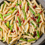 top down view of wooden bowl with garlic lemon asparagus pasta salad.