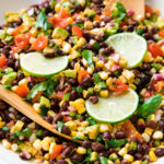 side angle view of black bean corn salad in a white bowl.