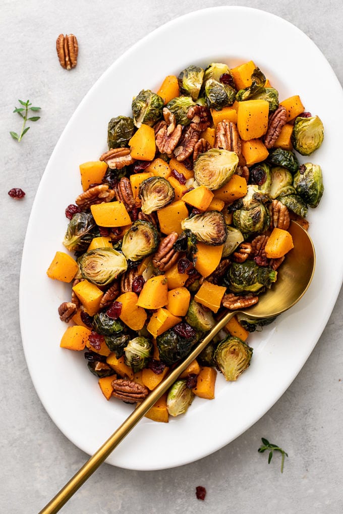 top down view of serving platter with roasted brussels sprouts and butternut squash with cranberries and pecans.
