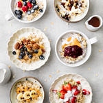 top down view of 6 bowls of healthy oatmeal with various toppings.