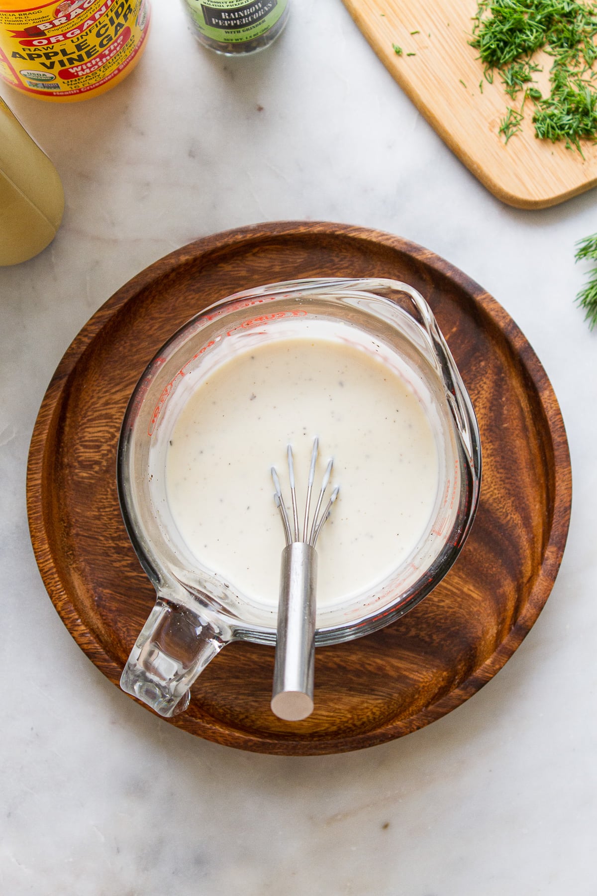 top down view of creamy vegan macaroni salad dressing freshly mixed in a measuring cup.